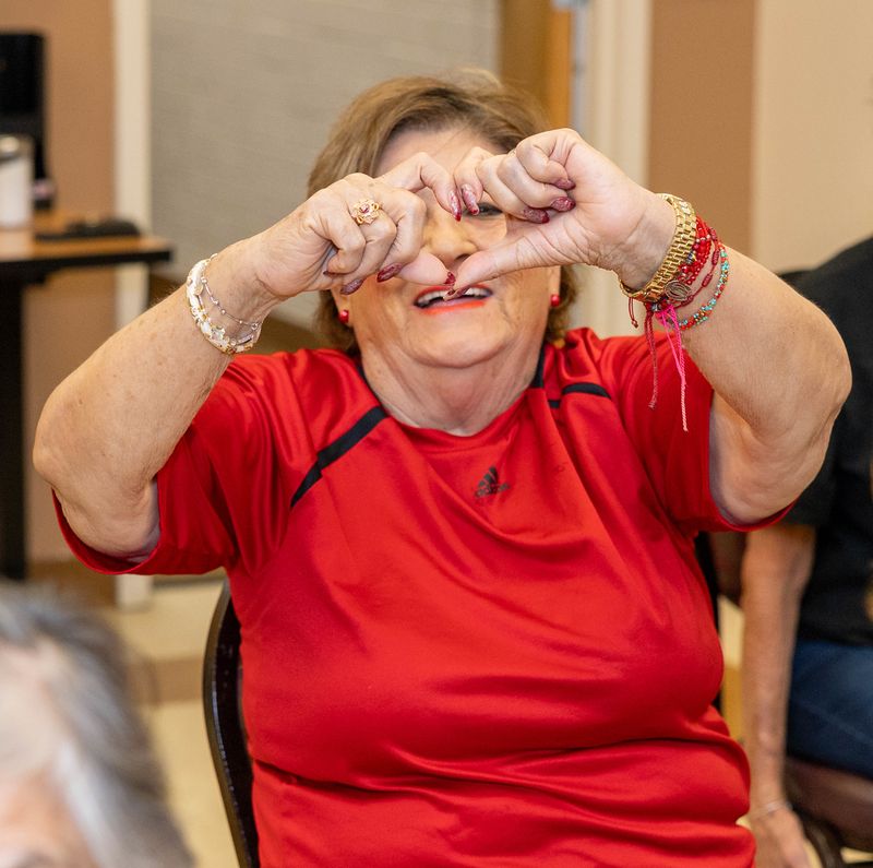 A participant makes a heart shape with her hands.